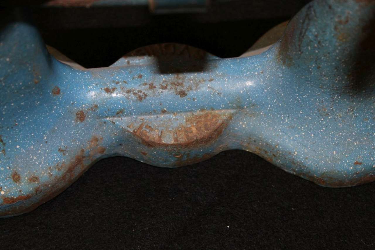 Blue metal clamp with rust spots against a dark background