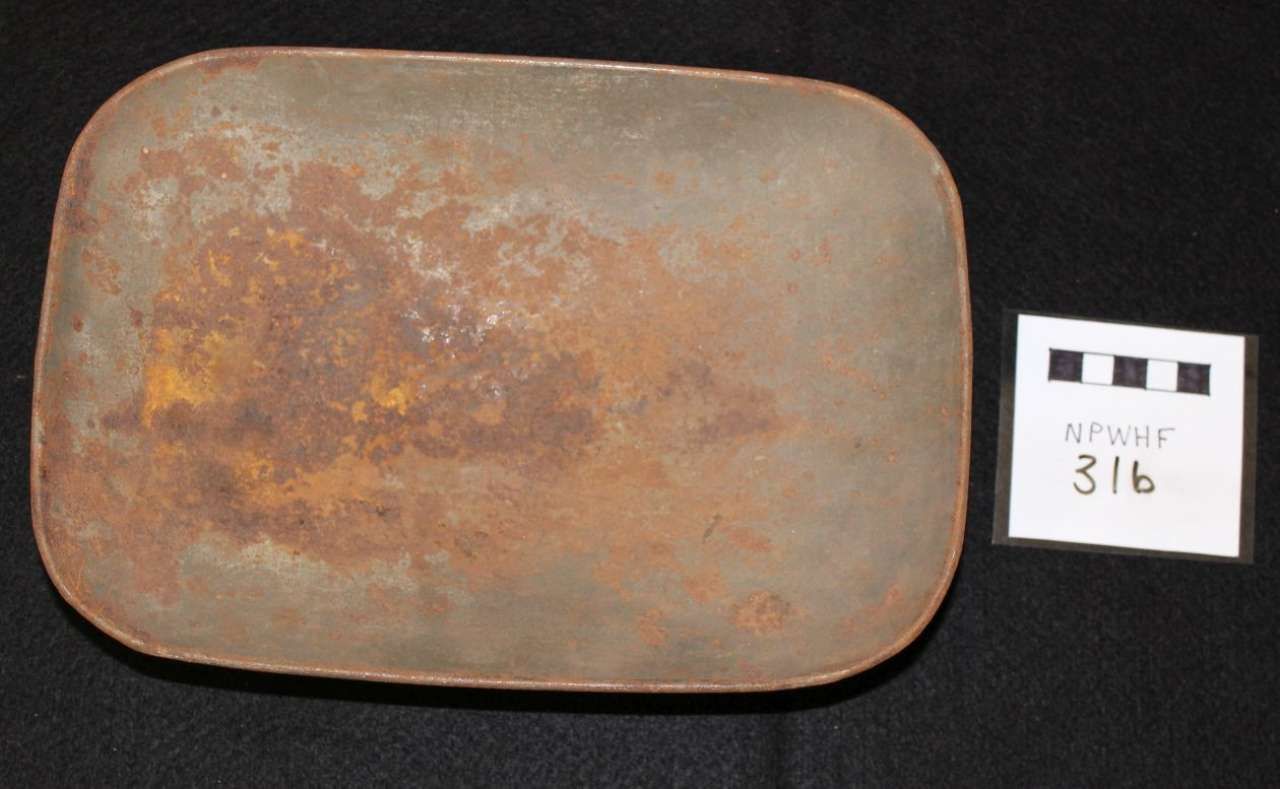 Rusty rectangular metal plate beside a small white label marked “316”
