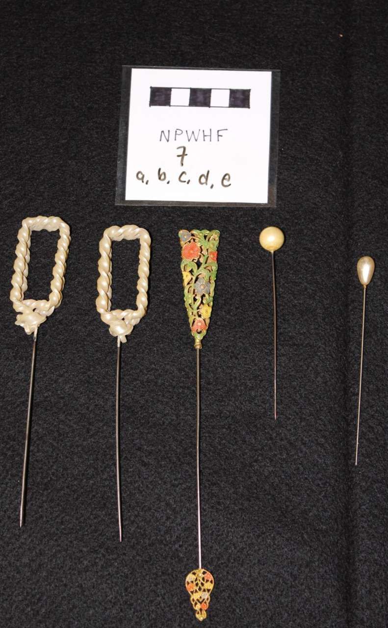 Five small beaded craft pieces and labels displayed on a black background