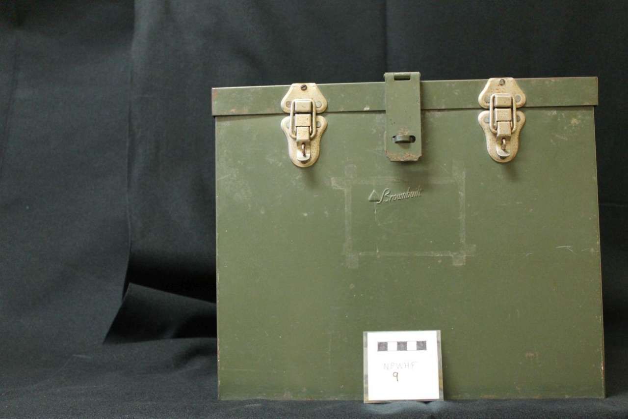 Green metal storage box with two latches, shown against a dark background