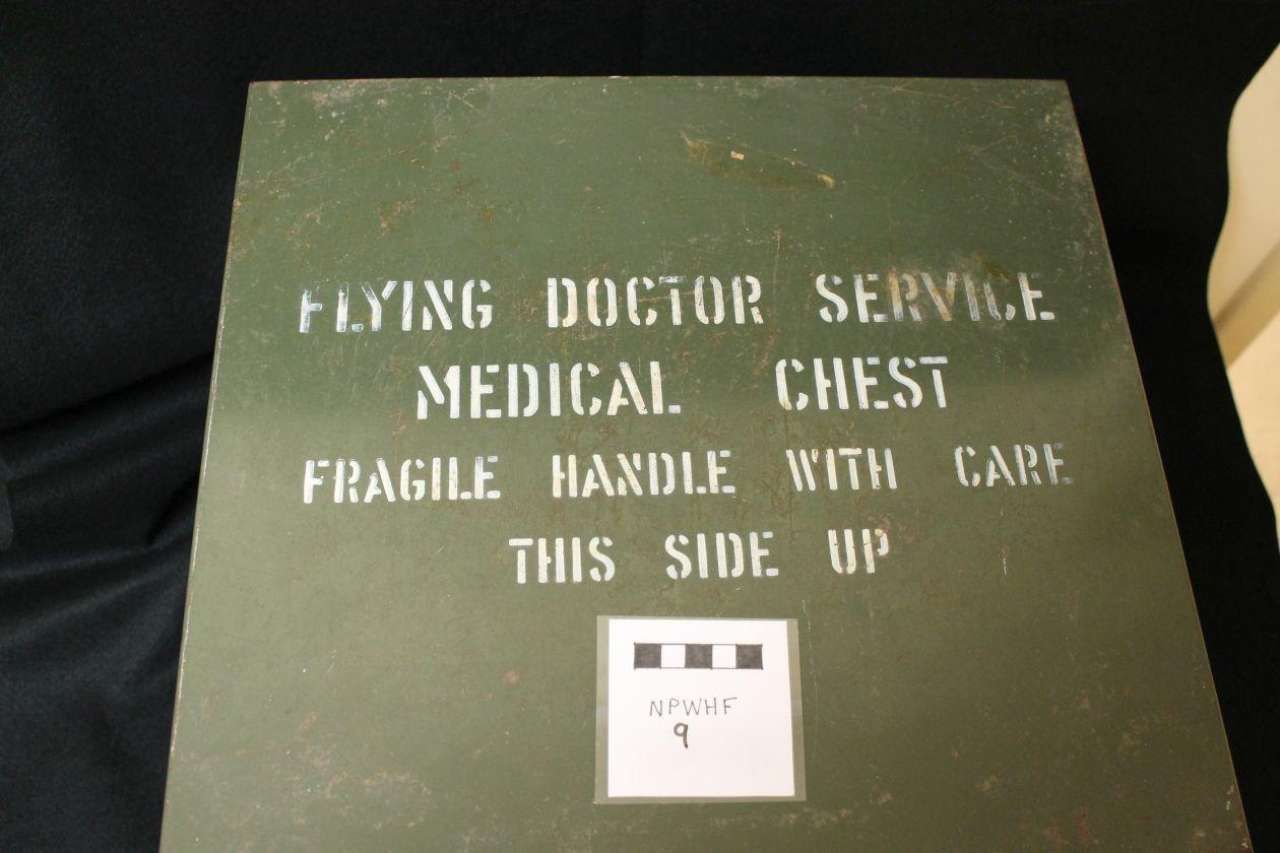 Green military-style case labeled “Flying Doctor Service Medical Chest,” with fragile and this side up text.