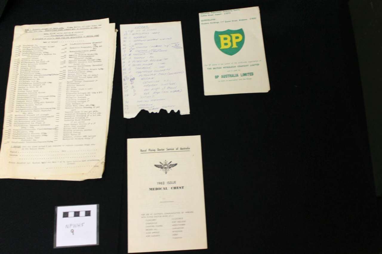 Assorted documents and a BP-branded booklet arranged on a black surface
