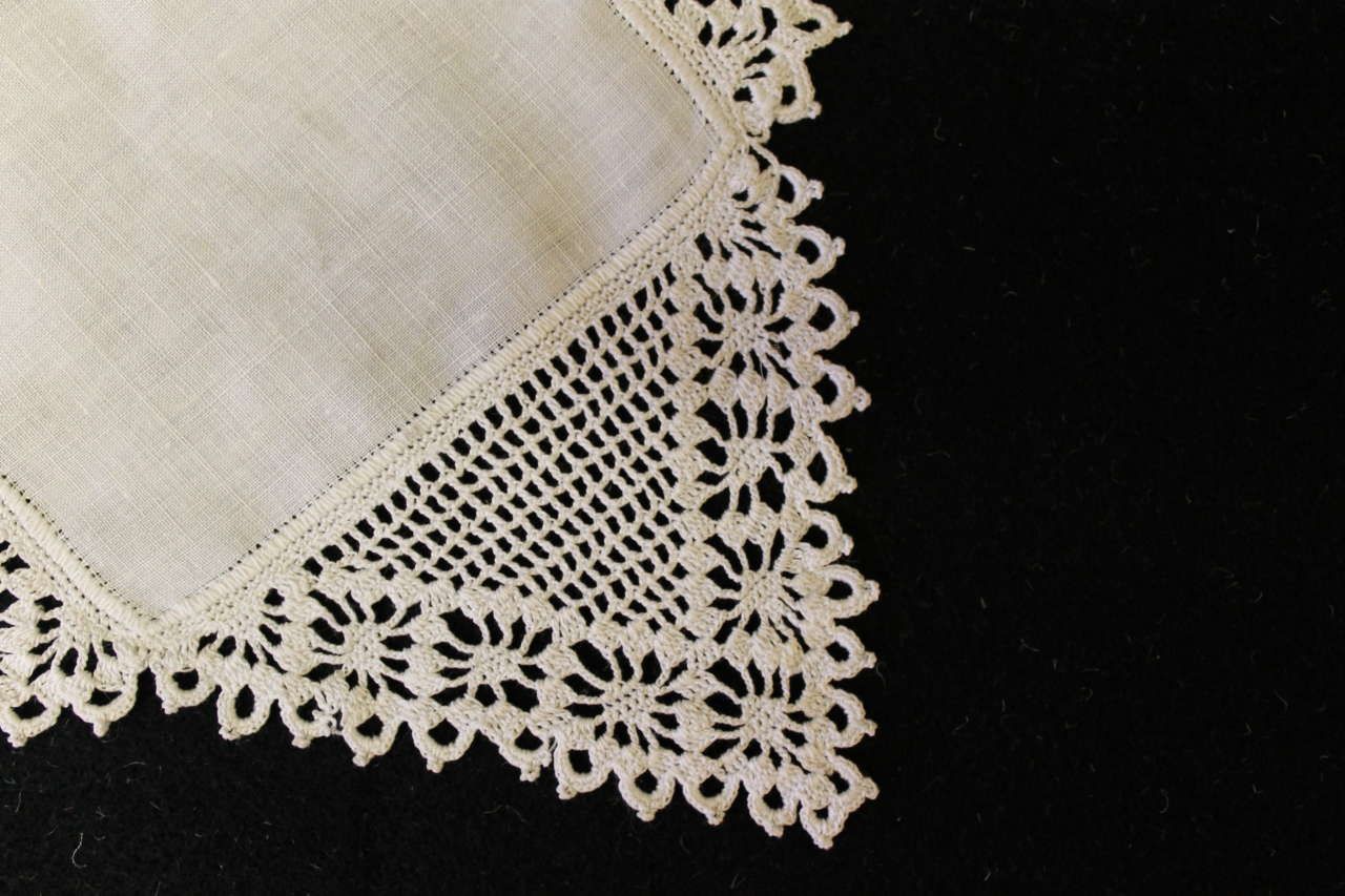 White lace-trimmed napkin or handkerchief on a black background