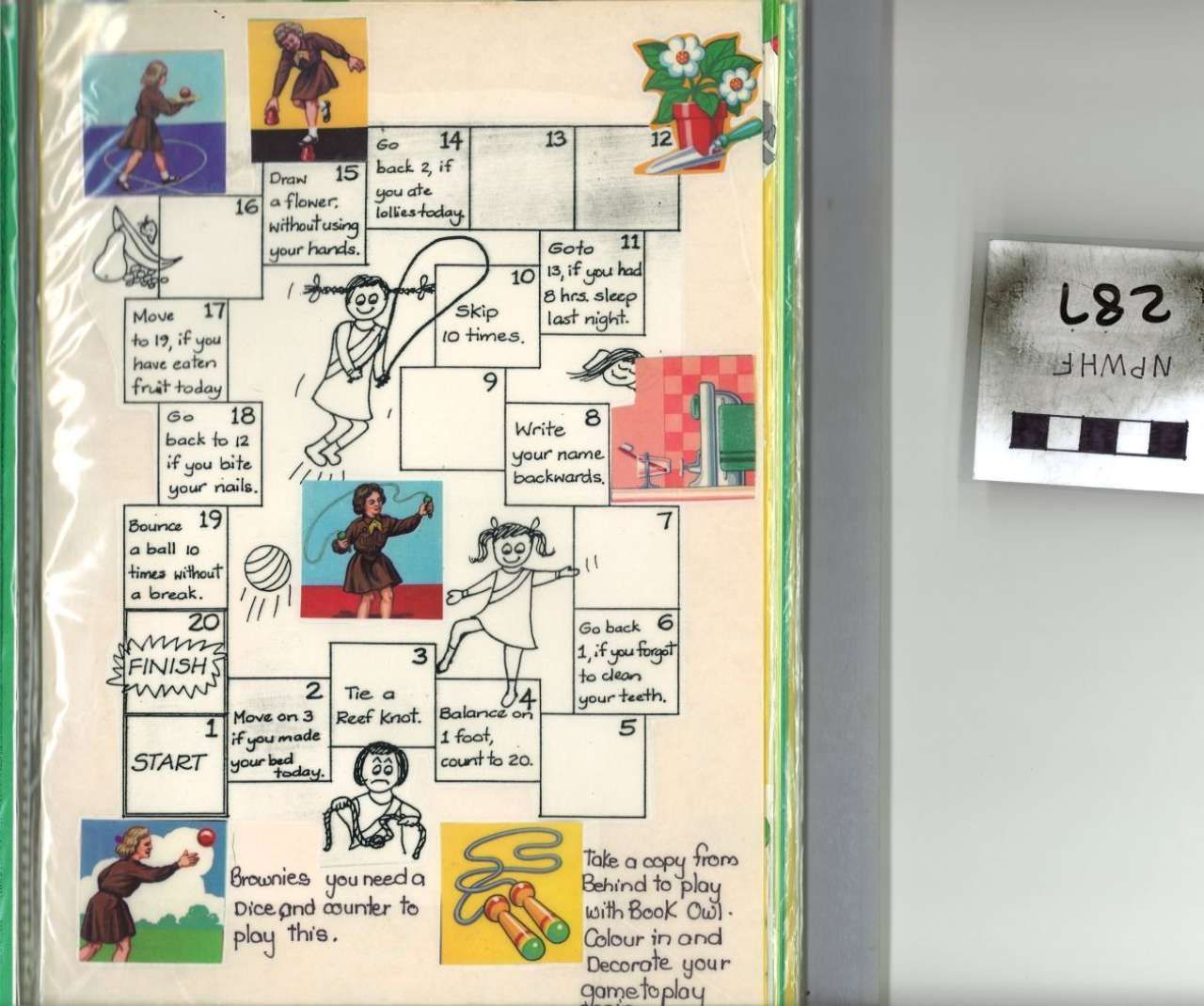 Handwritten activity chart with cartoon figures and colored blocks; small label on the wall beside it.