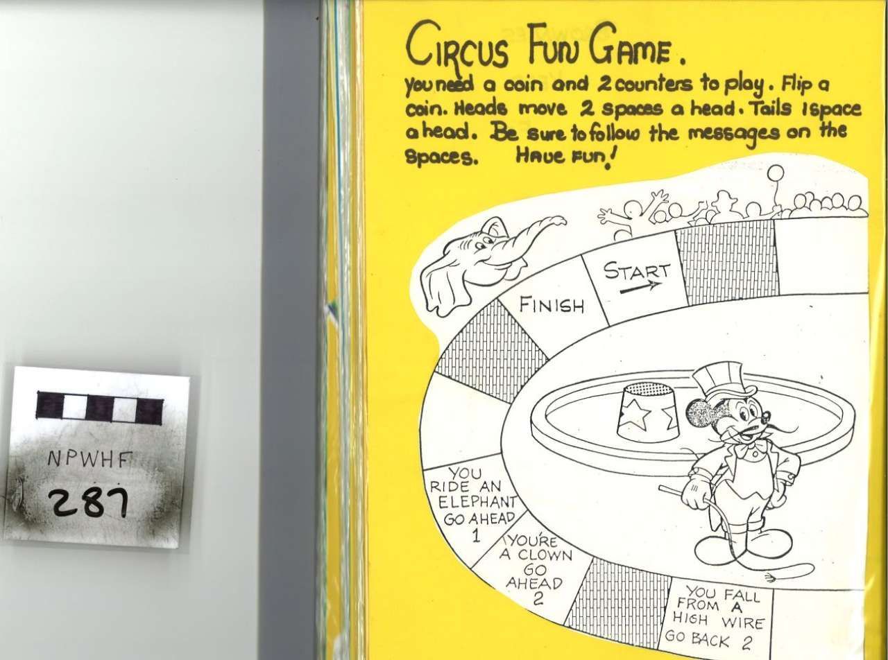 Circus Fun Game poster with a hand-drawn circular game board on a yellow wall beside a small device