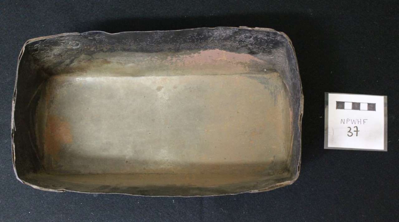 Rectangular black tray with a light-colored interior, shown next to a small label card on a dark background