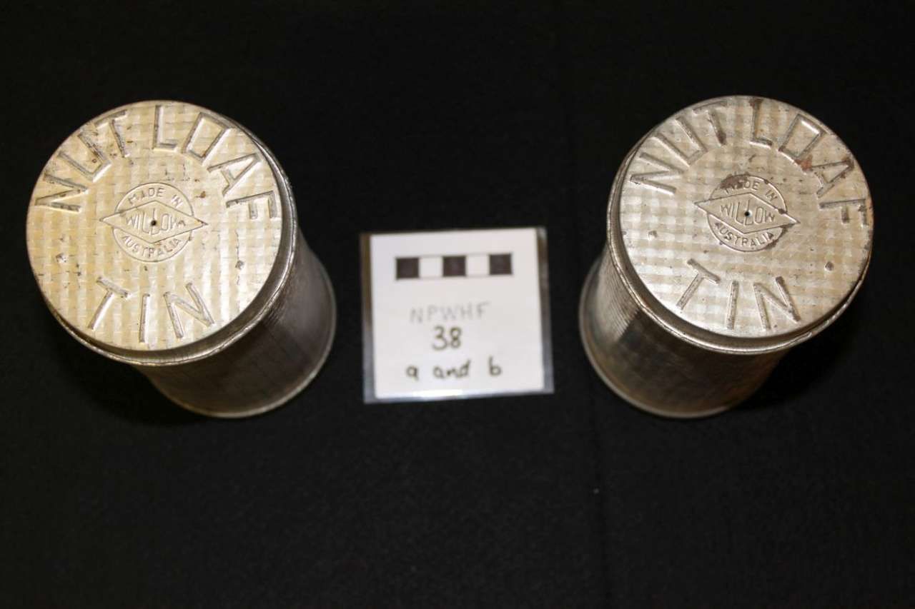 Two metallic cylinders flanking a small labeled card on a black background