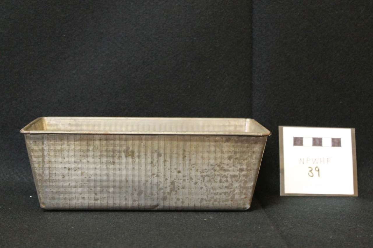 Rectangular woven basket with a small numbered card beside it on a dark background