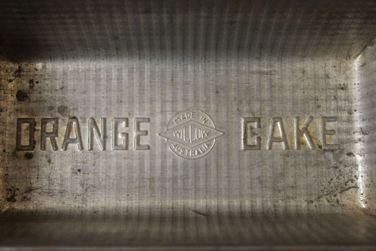 Metal tray embossed with the words “ORANGE CAKE” in the center