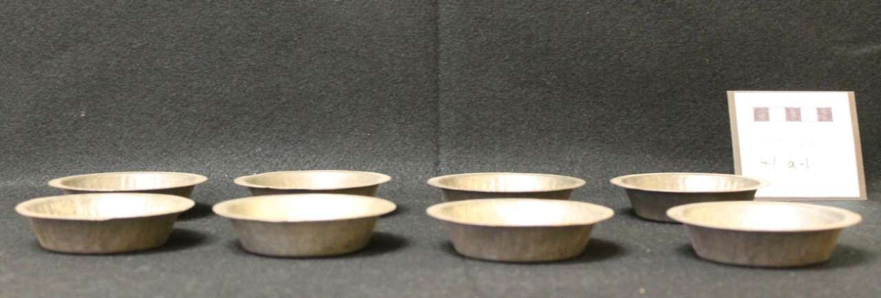 Row of small bowls on a table with a white sign at the right edge.