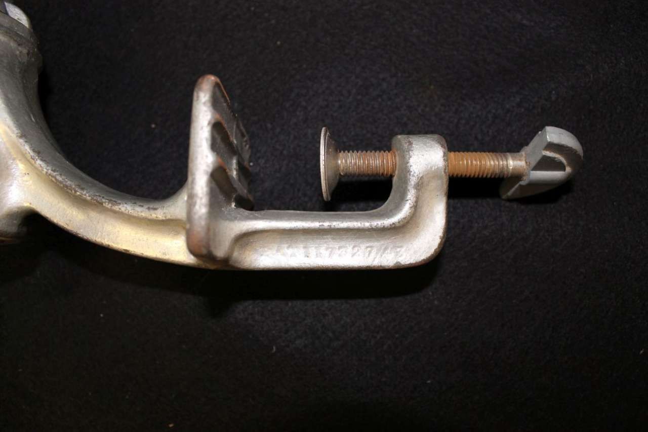 Close-up of a metal clamp with a threaded screw on a dark background