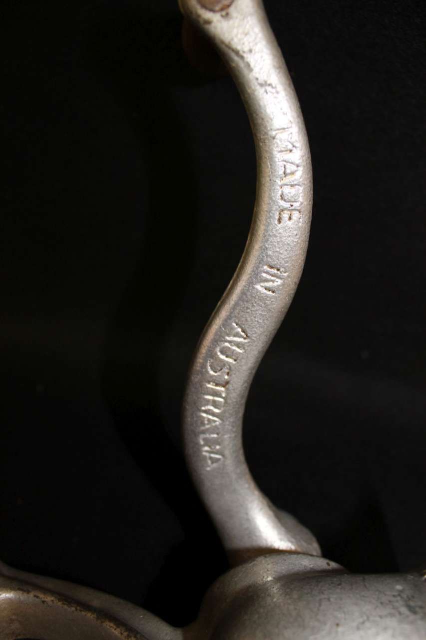 Close-up of a silver metal tool handle engraved “MADE IN AUSTRALIA” on a dark background