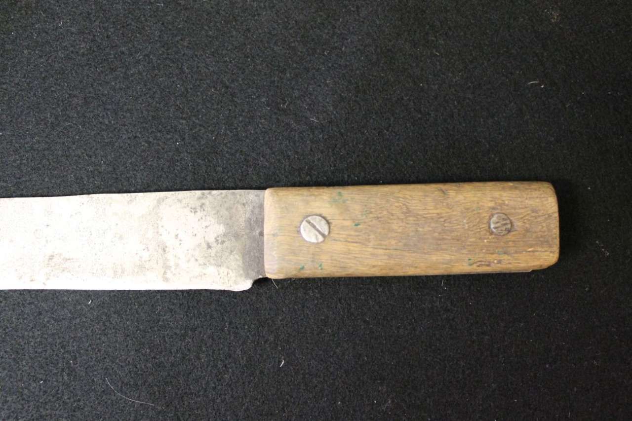Metal knife with a worn wooden handle on a dark surface