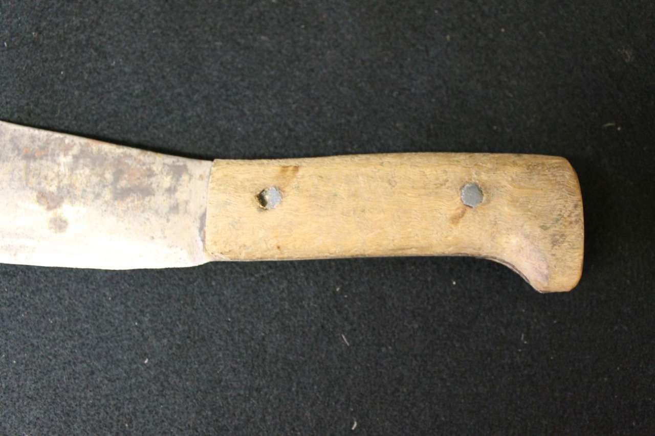 Close-up of a rusty knife with a worn wooden handle on a dark background
