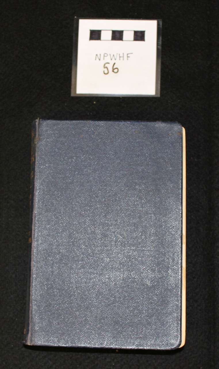 Two dark textured notebooks stacked vertically with a small white label card above them on a black background