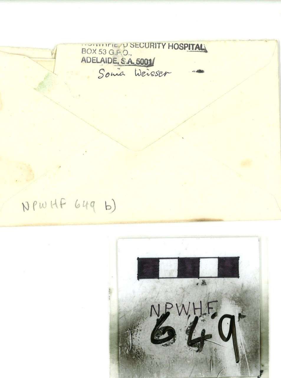 Close-up of a pale envelope with handwritten address and a small black-and-white numbered label marked 649.