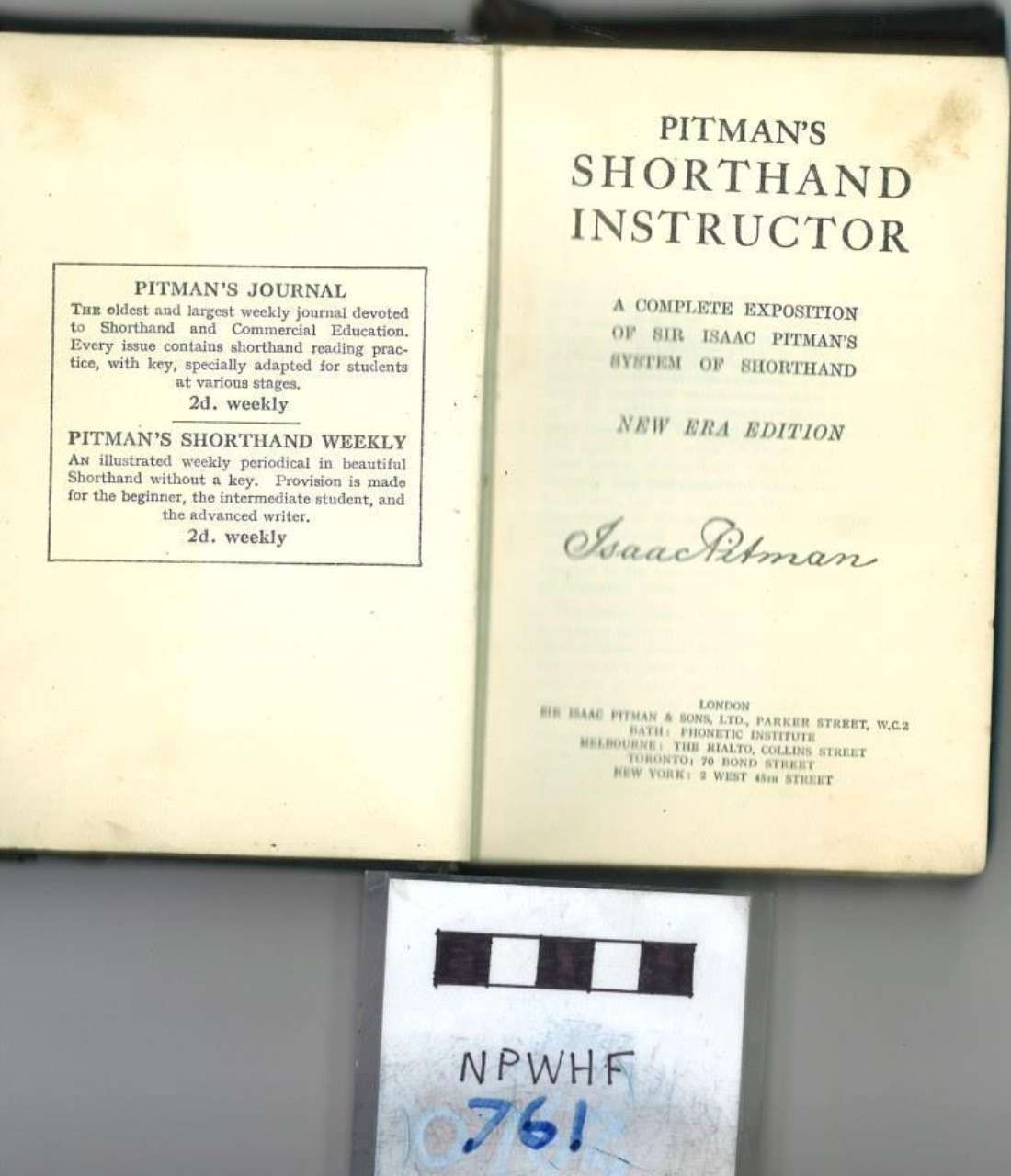 Open book titled “Pitman’s Shorthand Instructor” with a small handwritten number card below it.