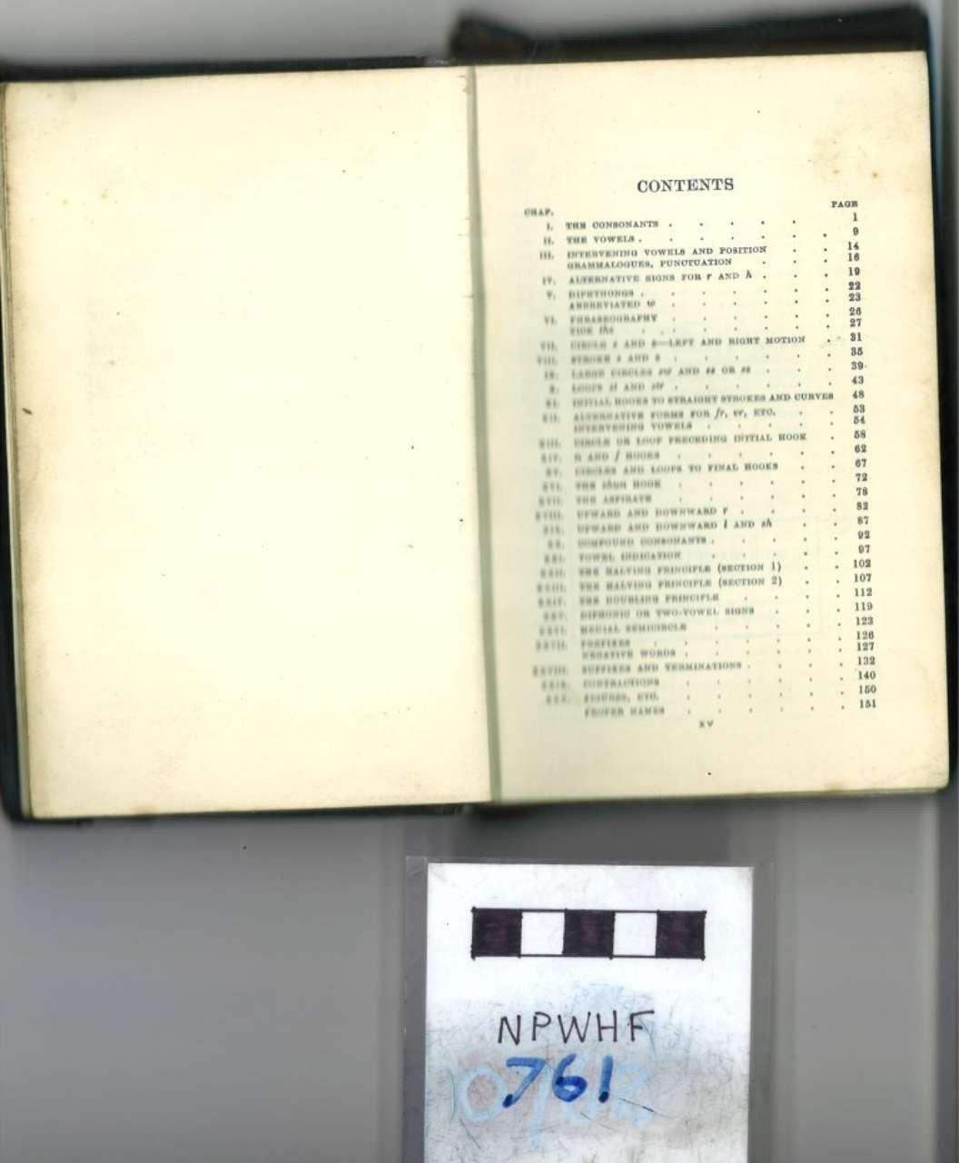 An open book showing a contents page, with a small black-and-white label below it.