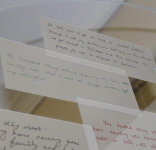 Scattered handwritten notes on white paper strips laid on a light table.