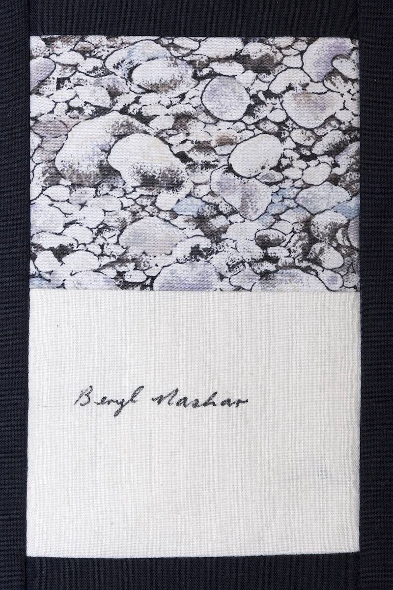 A black-and-white pebble pattern above a white card with handwritten signature text