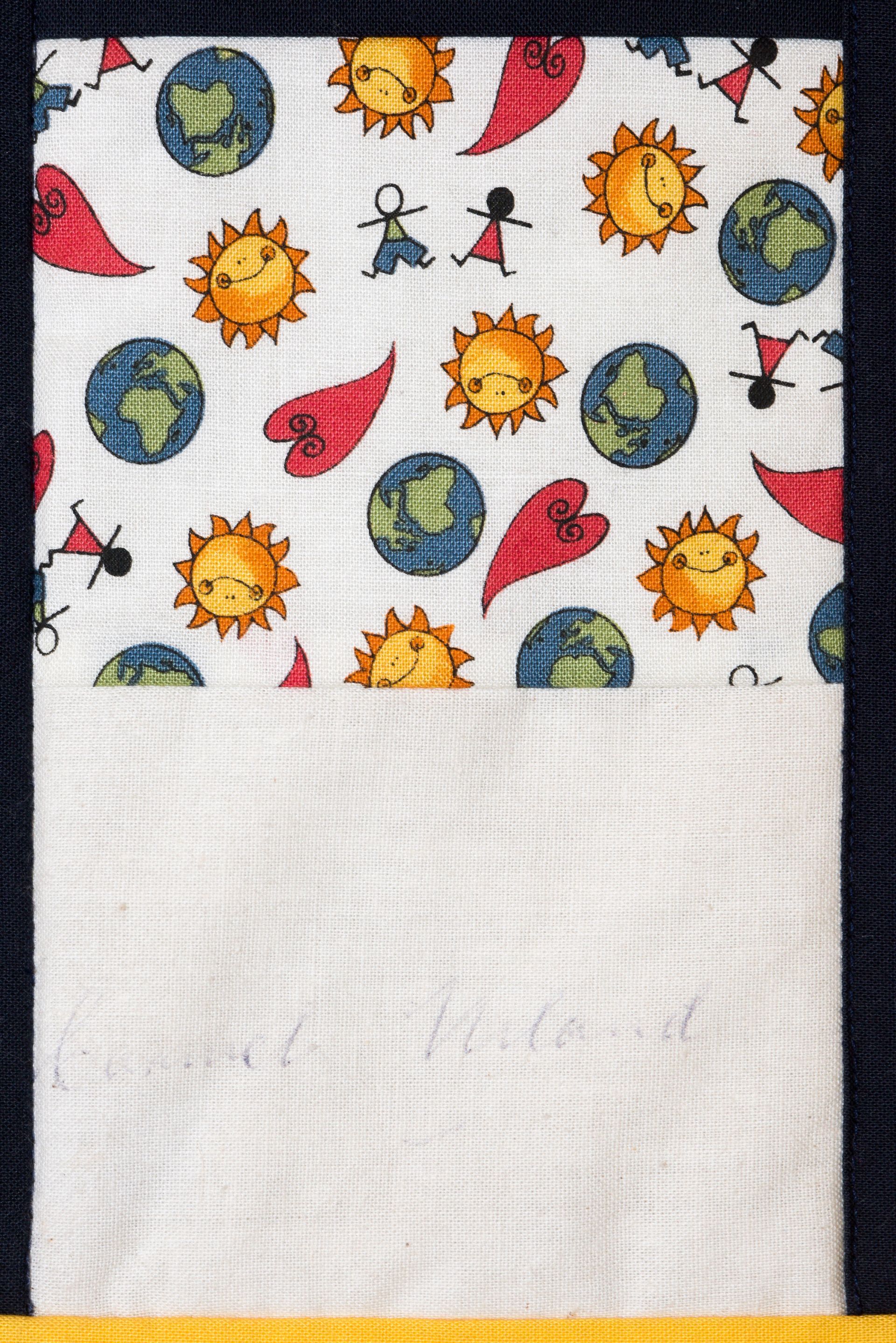 White cloth with colorful sun, moon, and Earth pattern above a plain white section