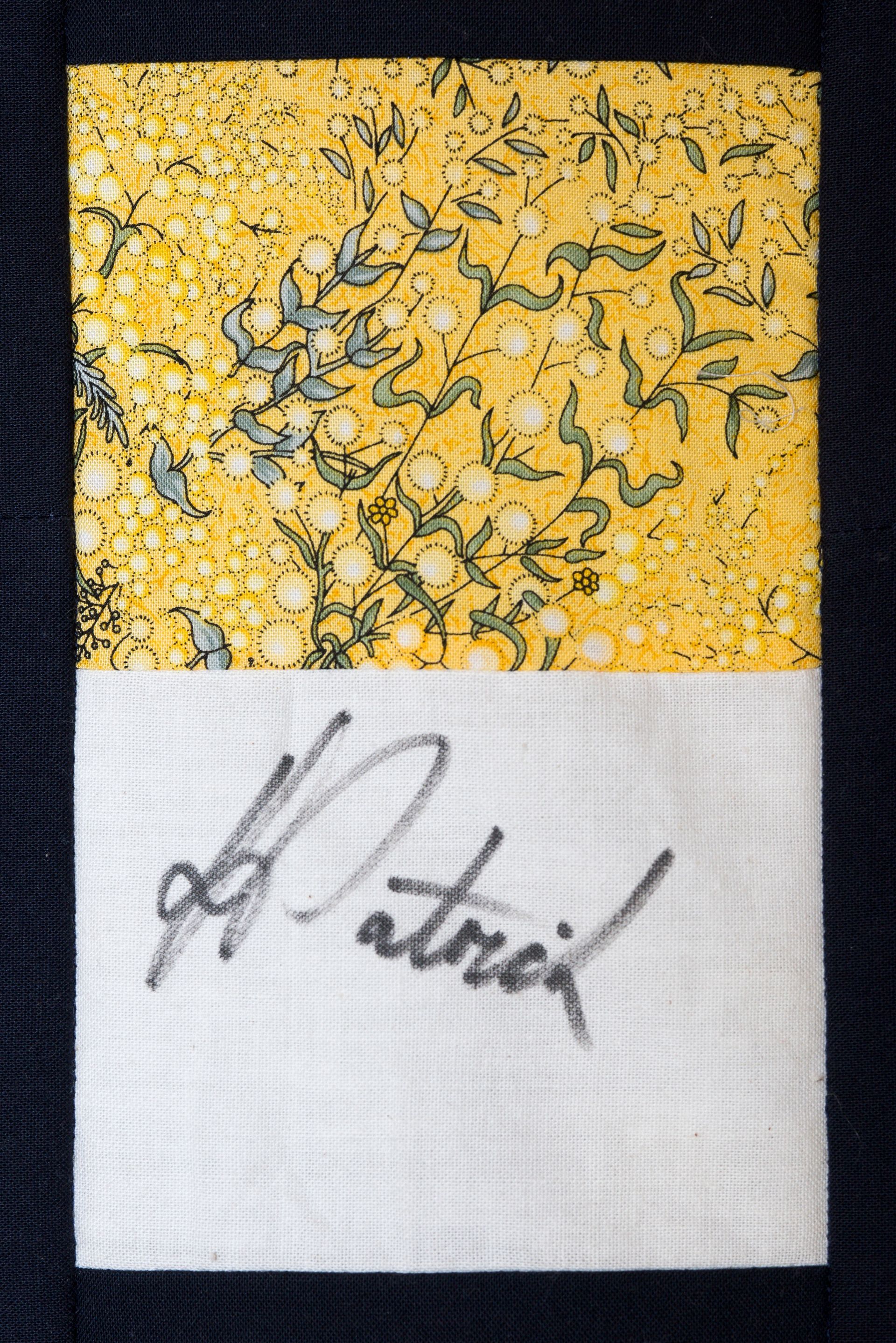 Yellow and white abstract painting with a black handwritten signature at the bottom