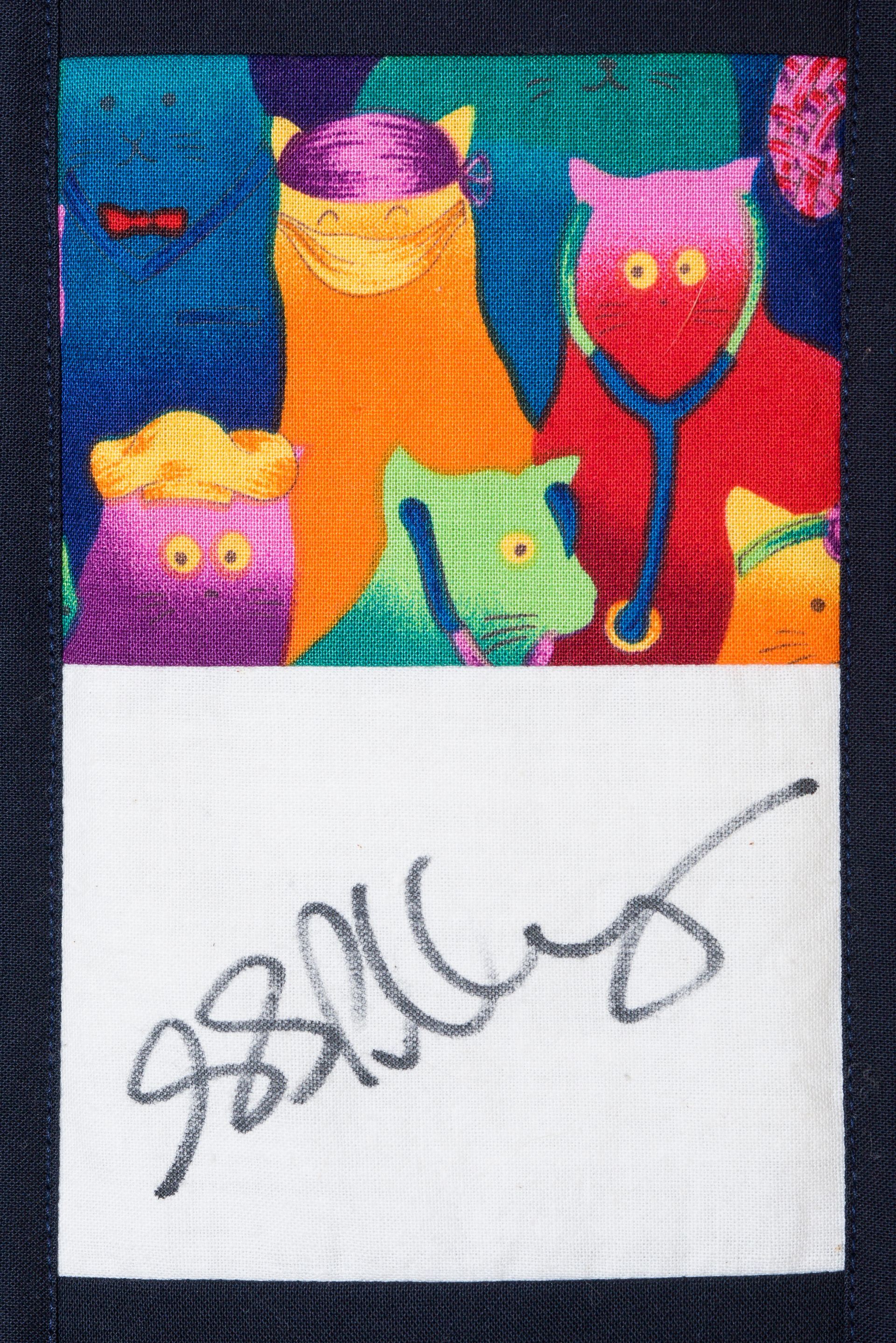 Colorful cat pattern above a white section with a gray signature
