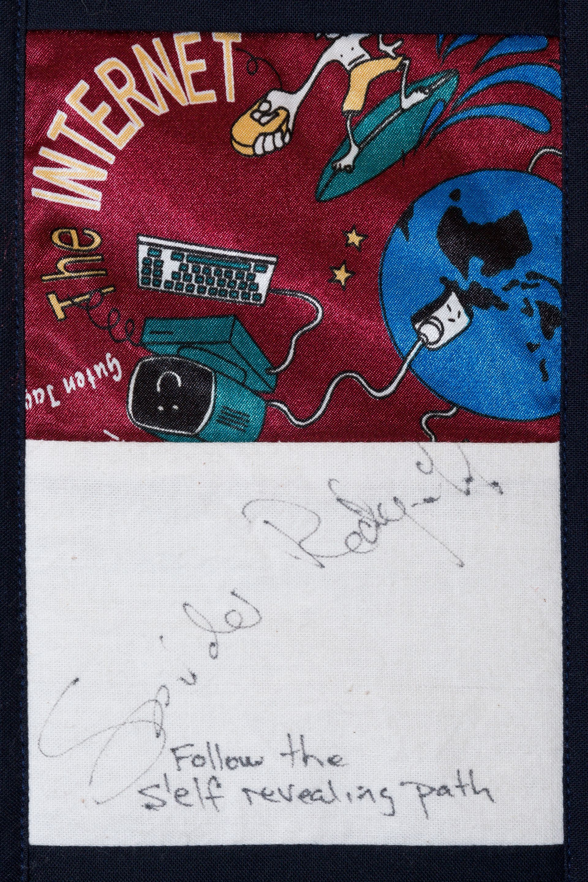 Handmade sign with red and blue collage art and handwritten text: “Follow the self revealing path.”
