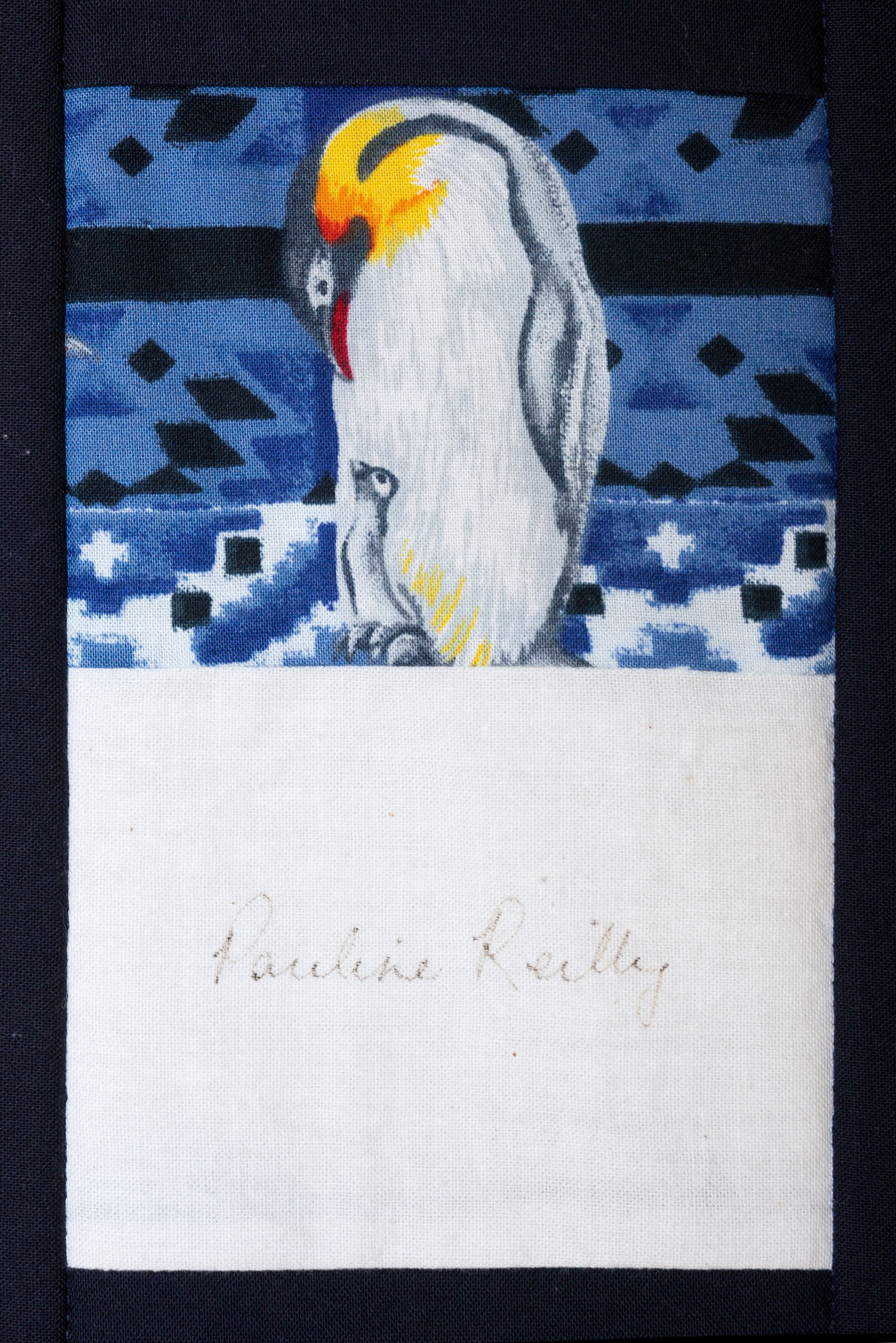 White bird on blue patterned fabric above a white label with faint text.