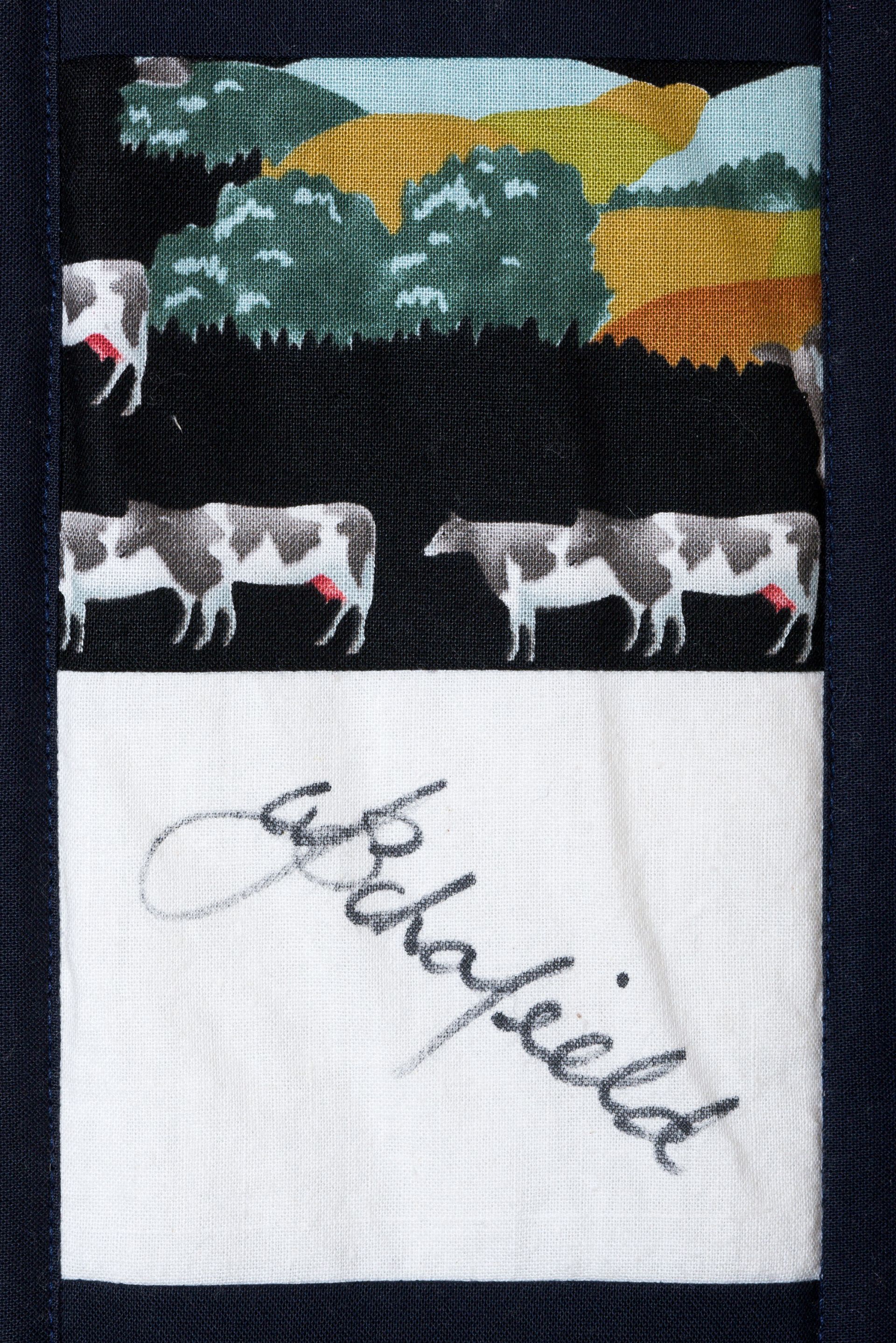 Hand-painted cows in a field under a dark sky, with a cursive signature below