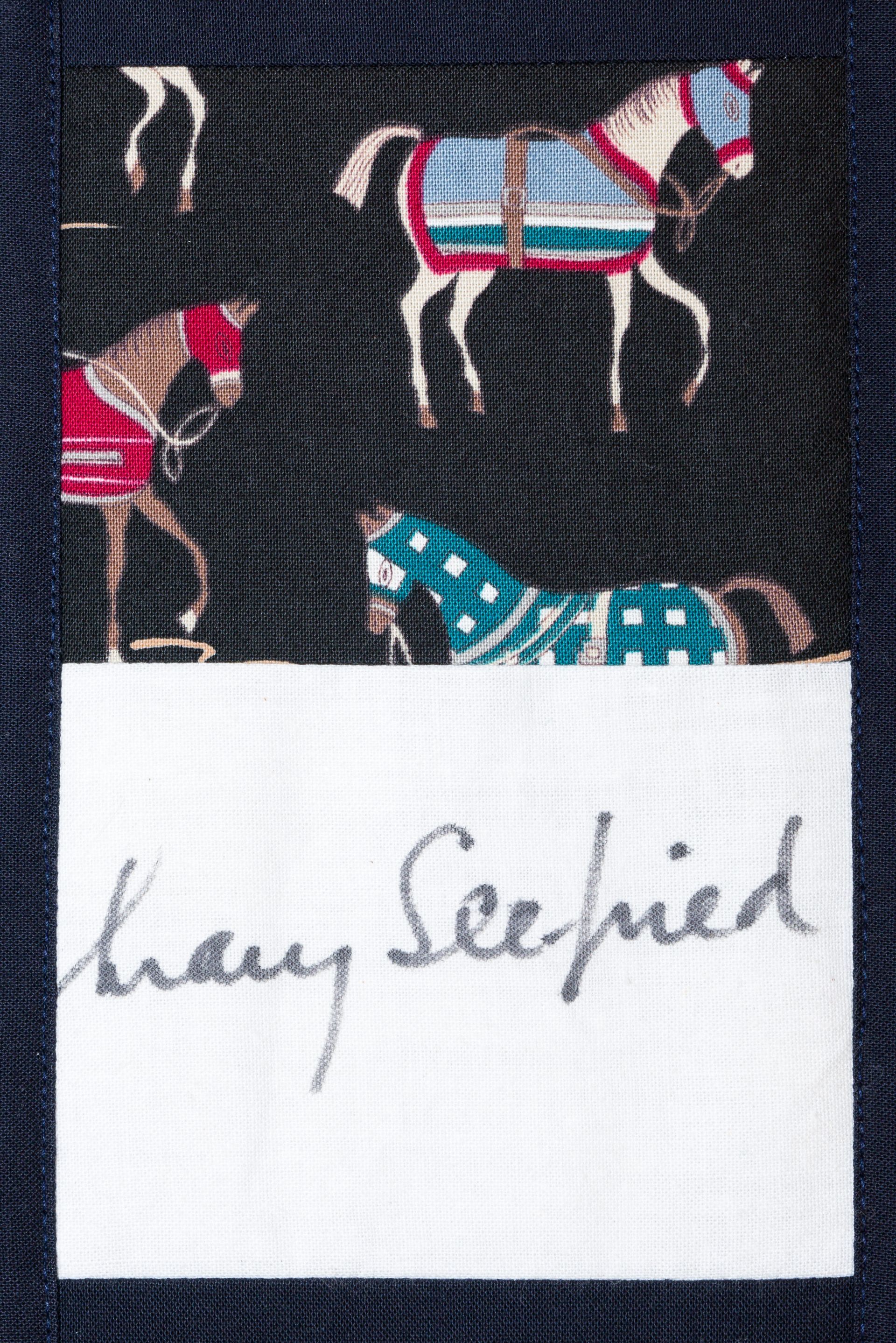 Horse-patterned fabric with a white label reading “Harry Seified”