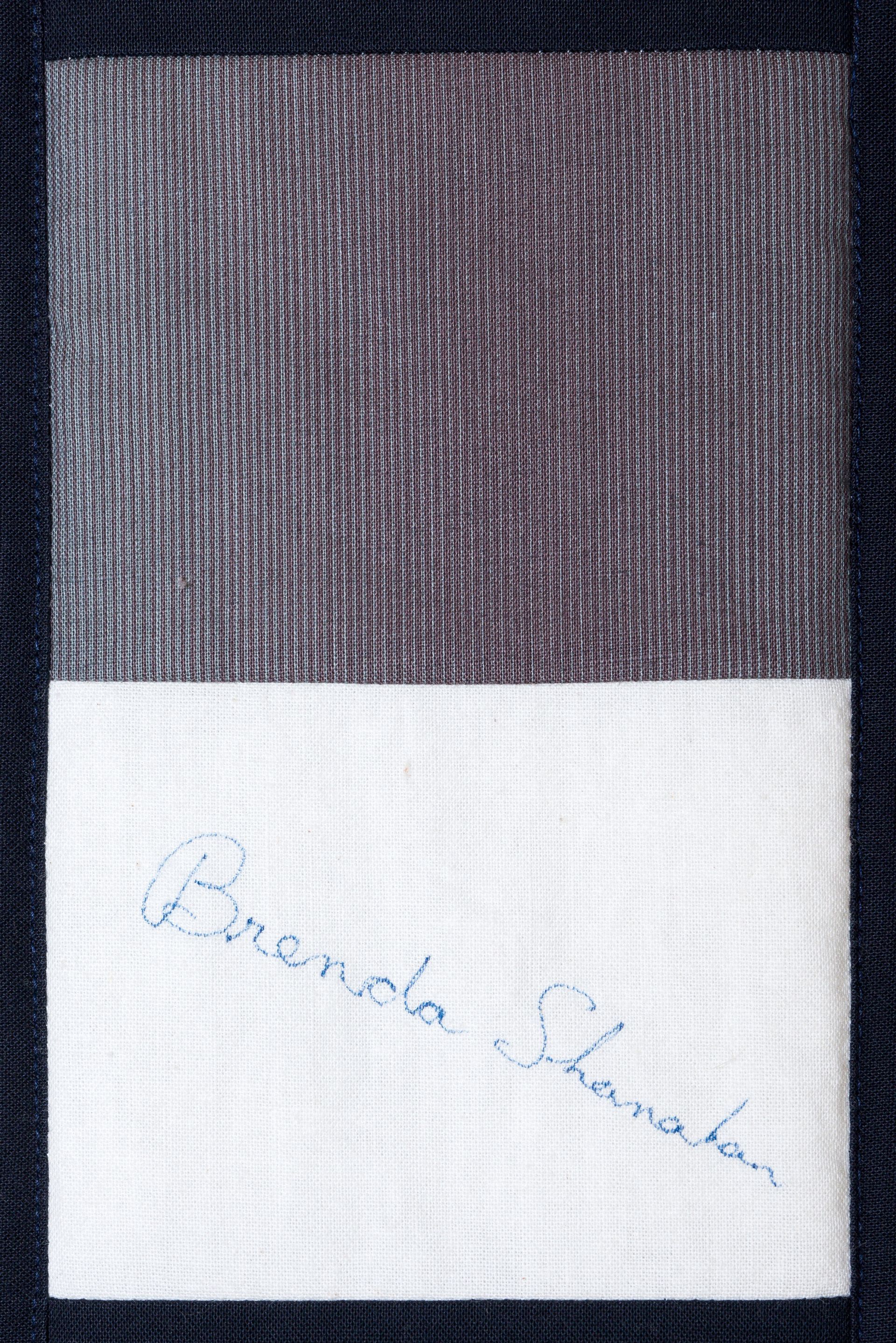 Two-tone notebook page with a handwritten signature on the white lower half.