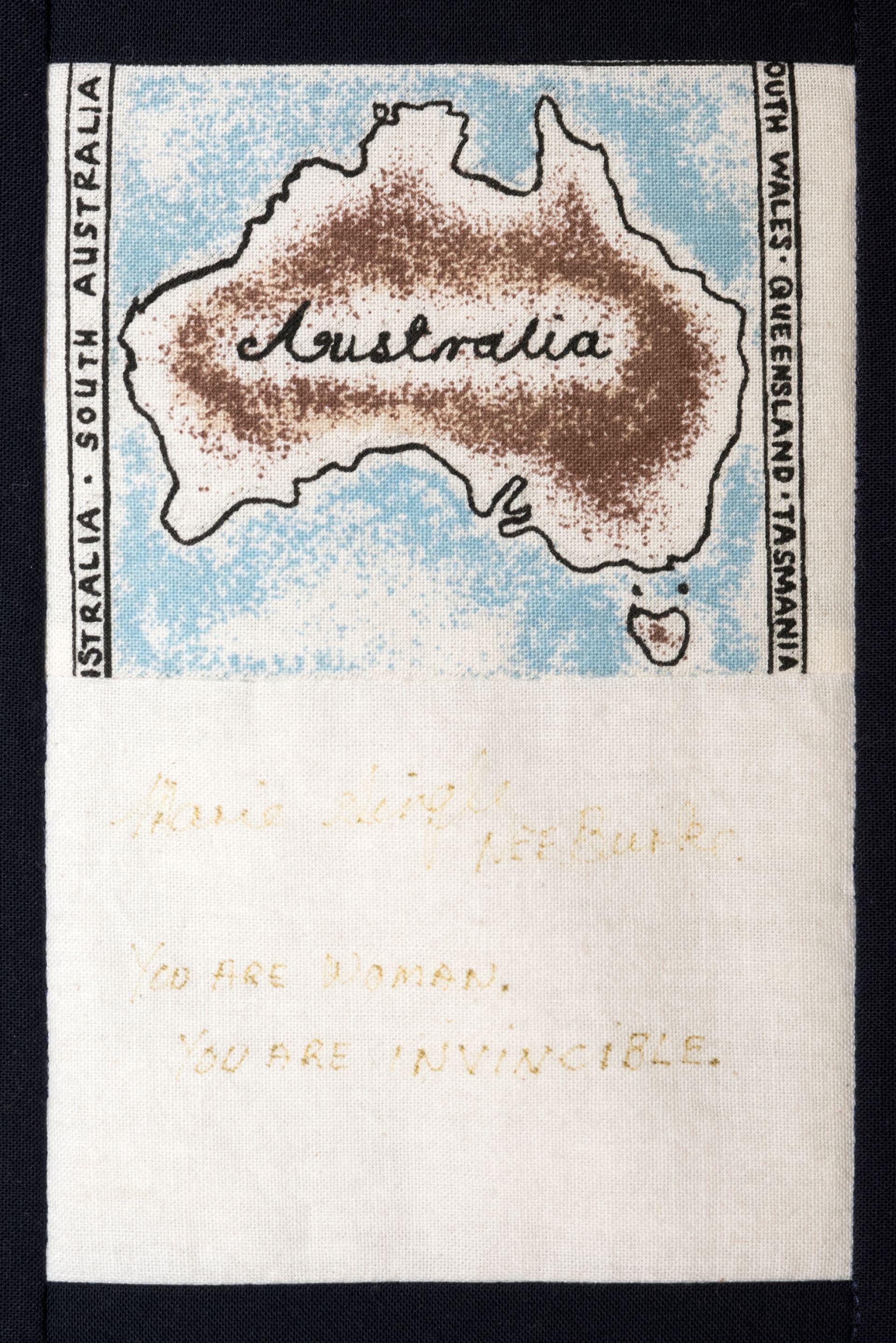 Hand-stitched map of Australia with stitched border labels and faded text on white fabric
