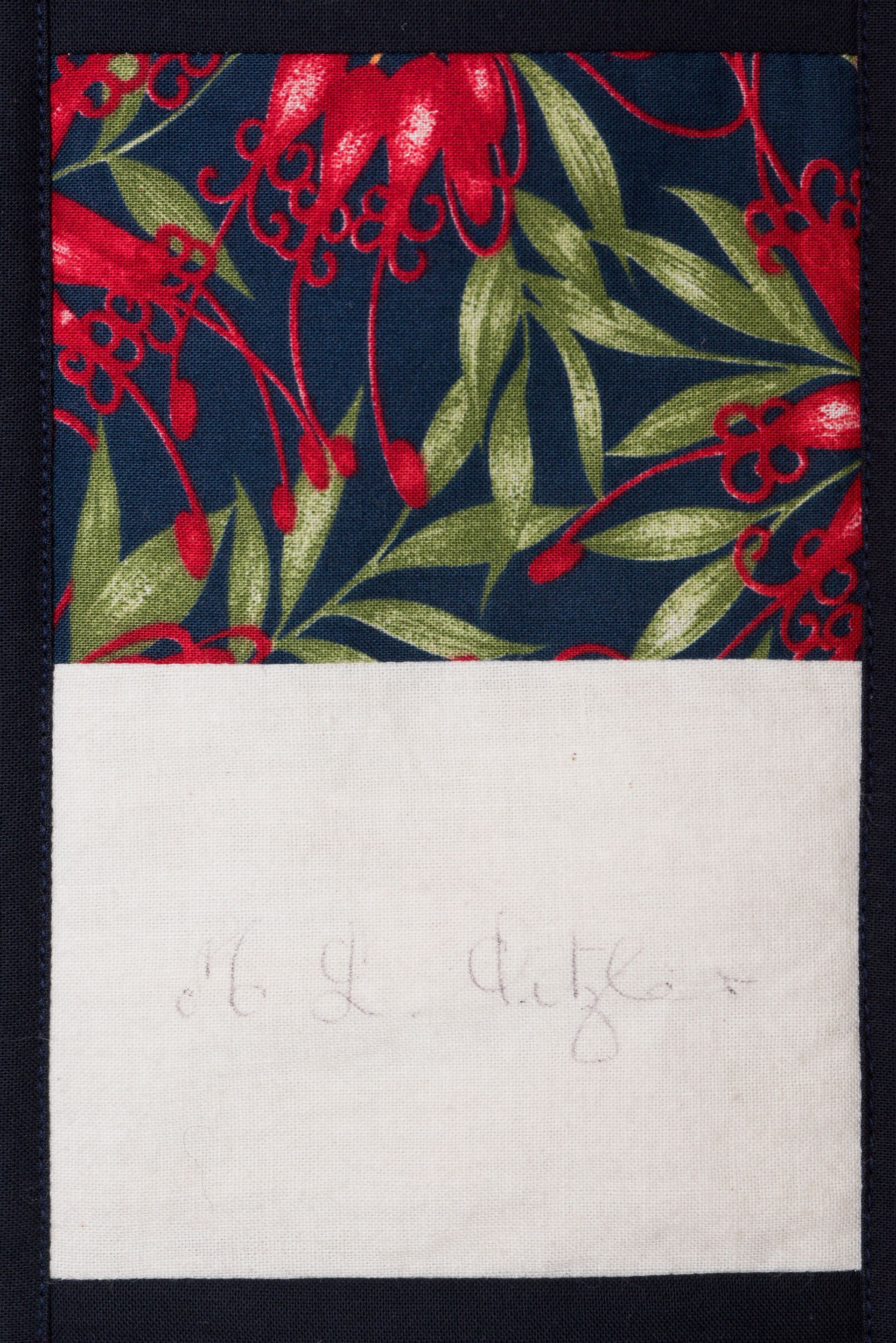 A red and green floral fabric swatch with a white rectangular label at the bottom.