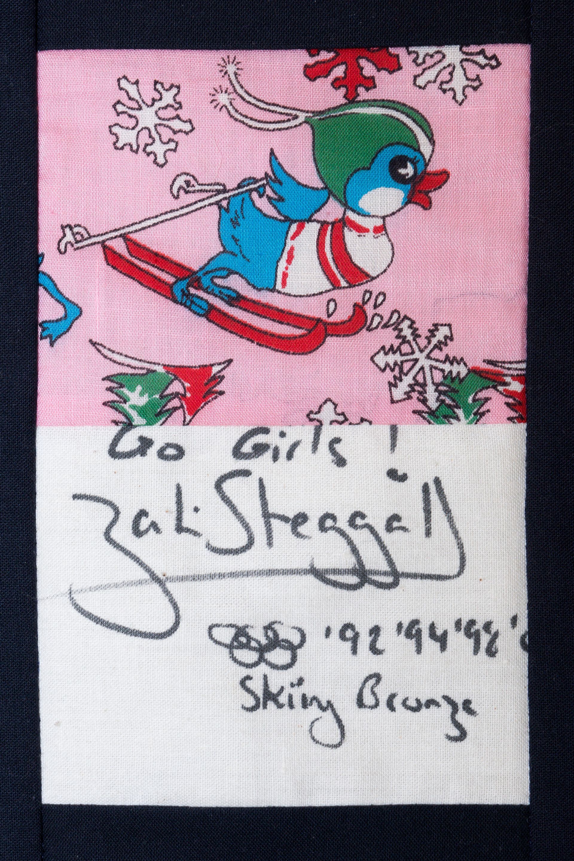 Skiing cartoon with “Go Girls! Go Stressy!” handwritten text on pink fabric patch