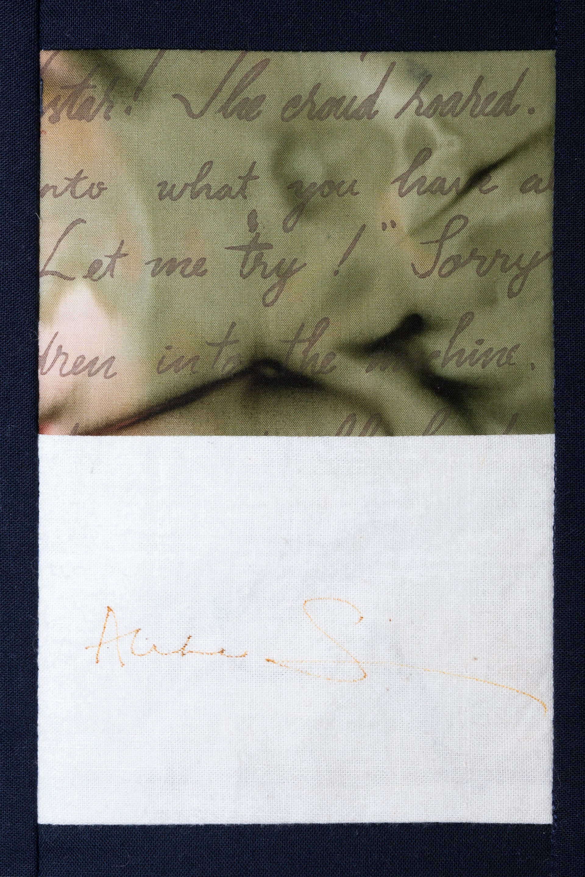 Close-up of a green patterned fabric above a white cloth panel with faint orange stitching.