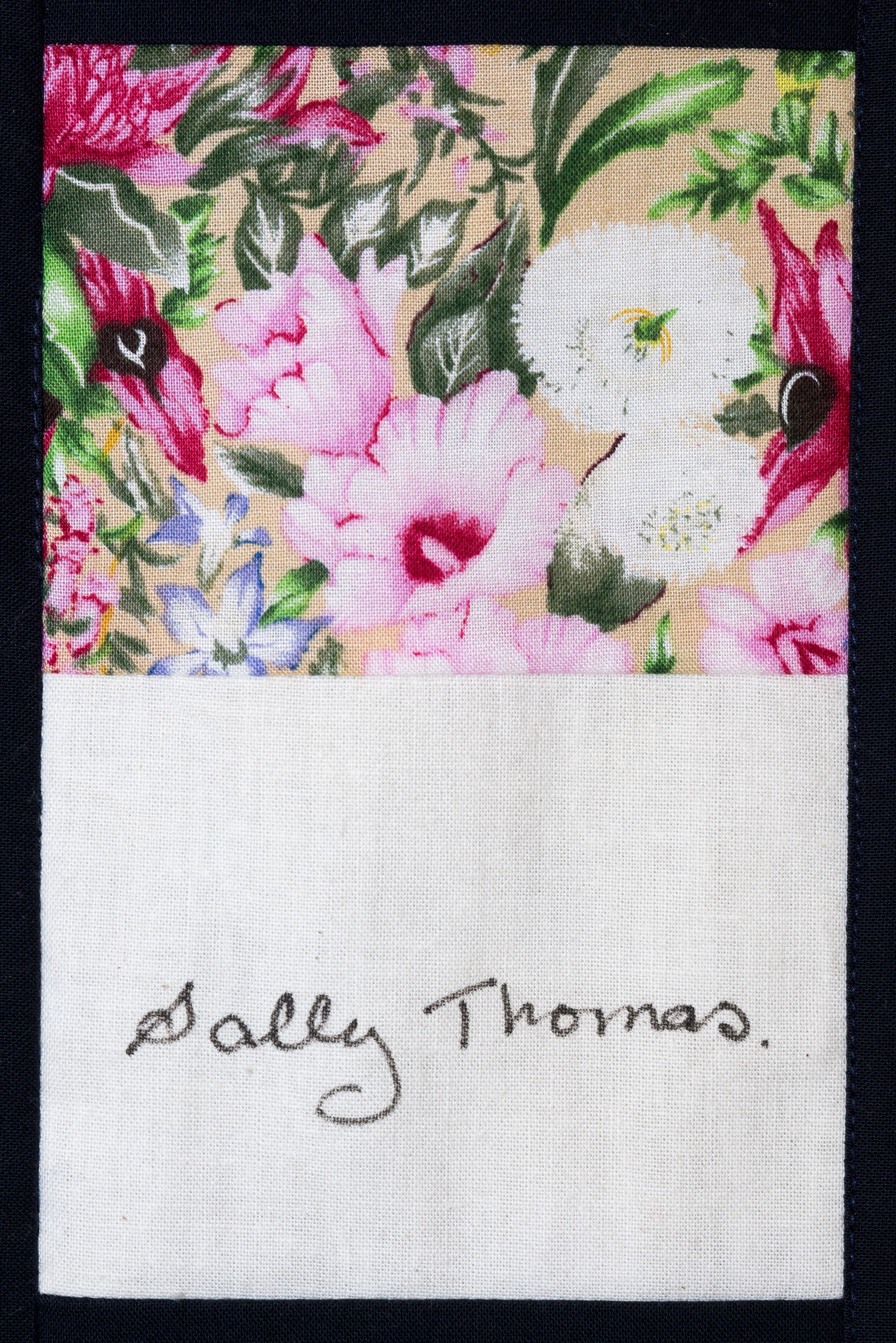 Floral artwork with pink and white flowers above a signed white section reading “Sally Thomas.”