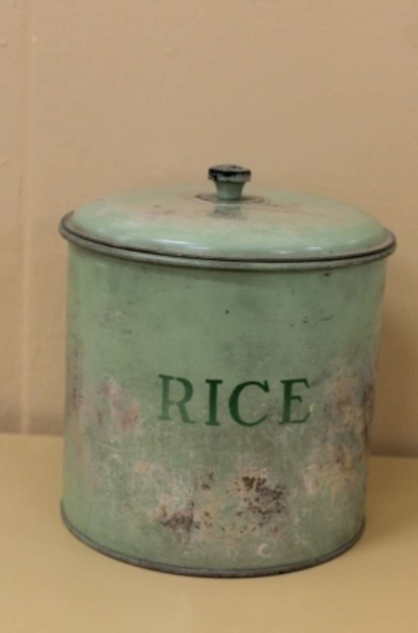 Mint-green tin can labeled “RICE” with a lid on a beige surface.