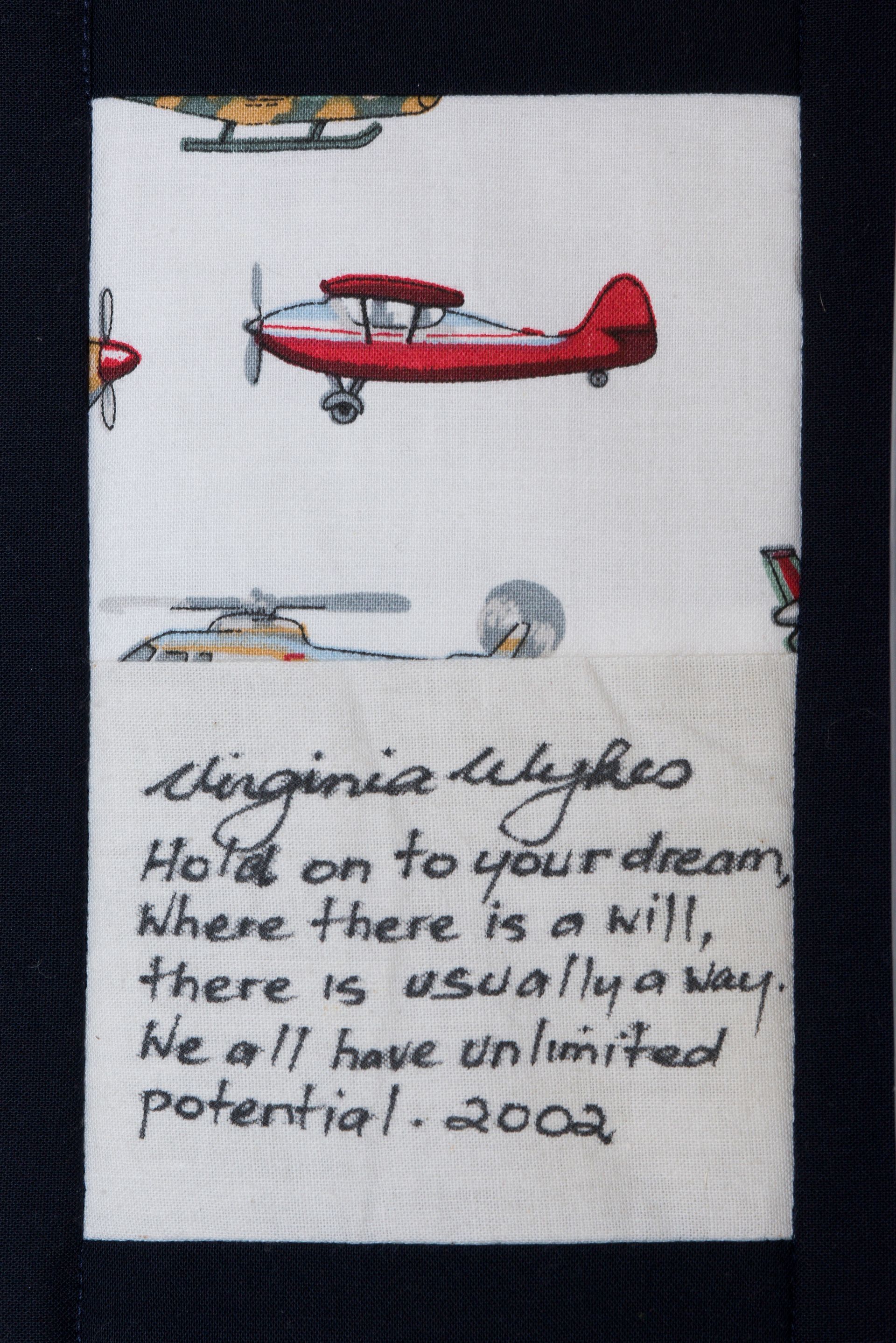 White fabric with red airplane embroidery and handwritten quote about dreams and potential.