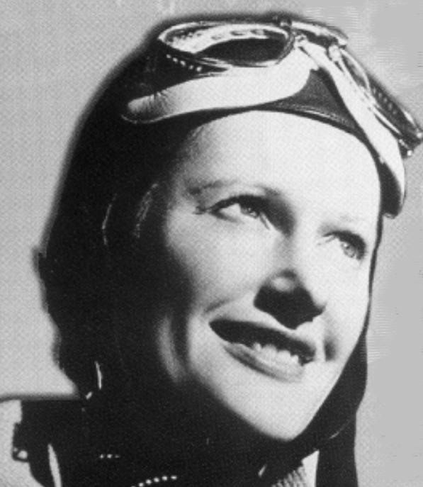 Black-and-white portrait of a smiling pilot wearing aviator goggles and a leather cap.