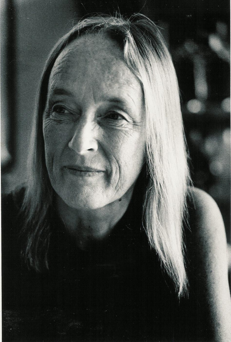 Black-and-white portrait of a long-haired woman looking slightly off-camera with a faint smile