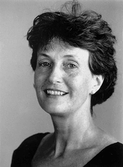 Black-and-white portrait of a smiling woman with short dark hair against a plain background