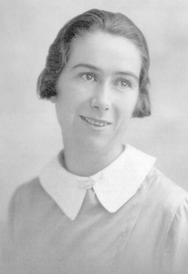 Black-and-white portrait of a smiling woman with short hair and a white collared blouse