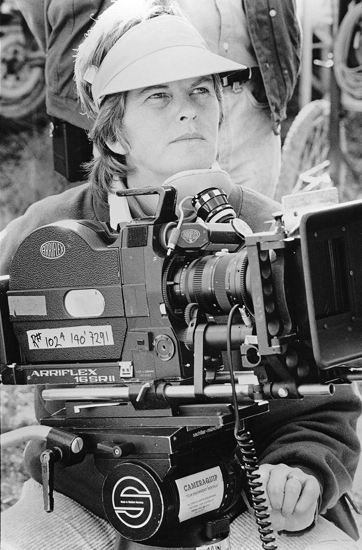 Person in a hard hat operating a film camera on a set