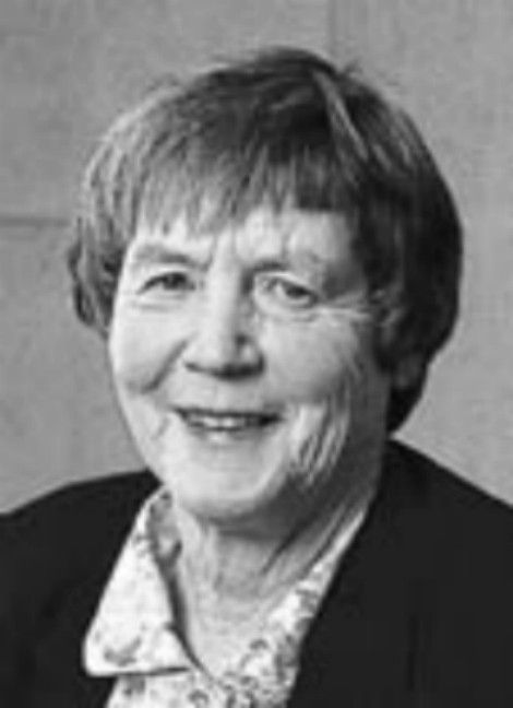 Black-and-white portrait of a smiling person with short hair and a collared shirt