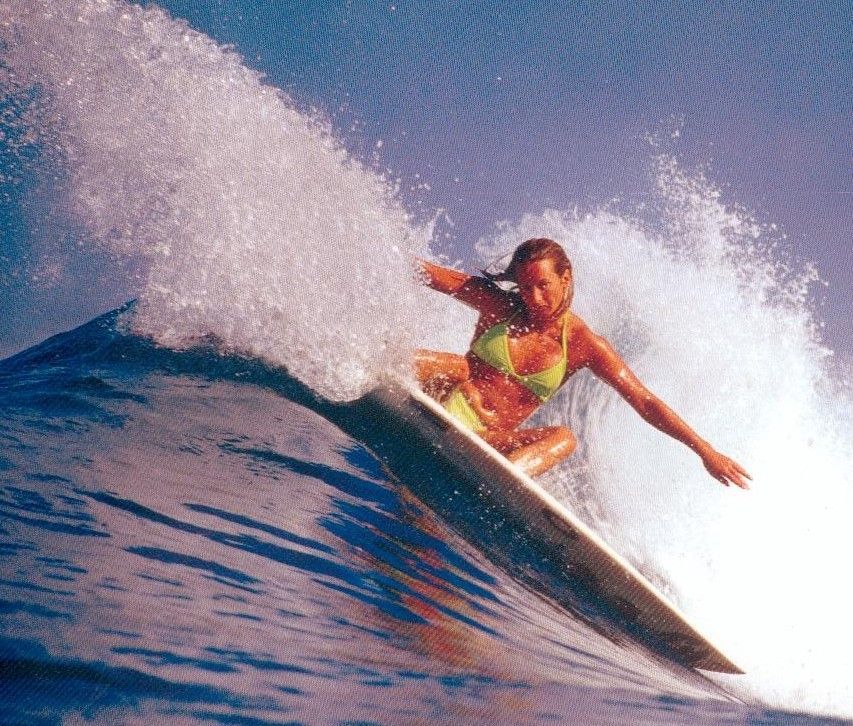 Surfer in a colorful wetsuit riding a wave, spray crashing around the board