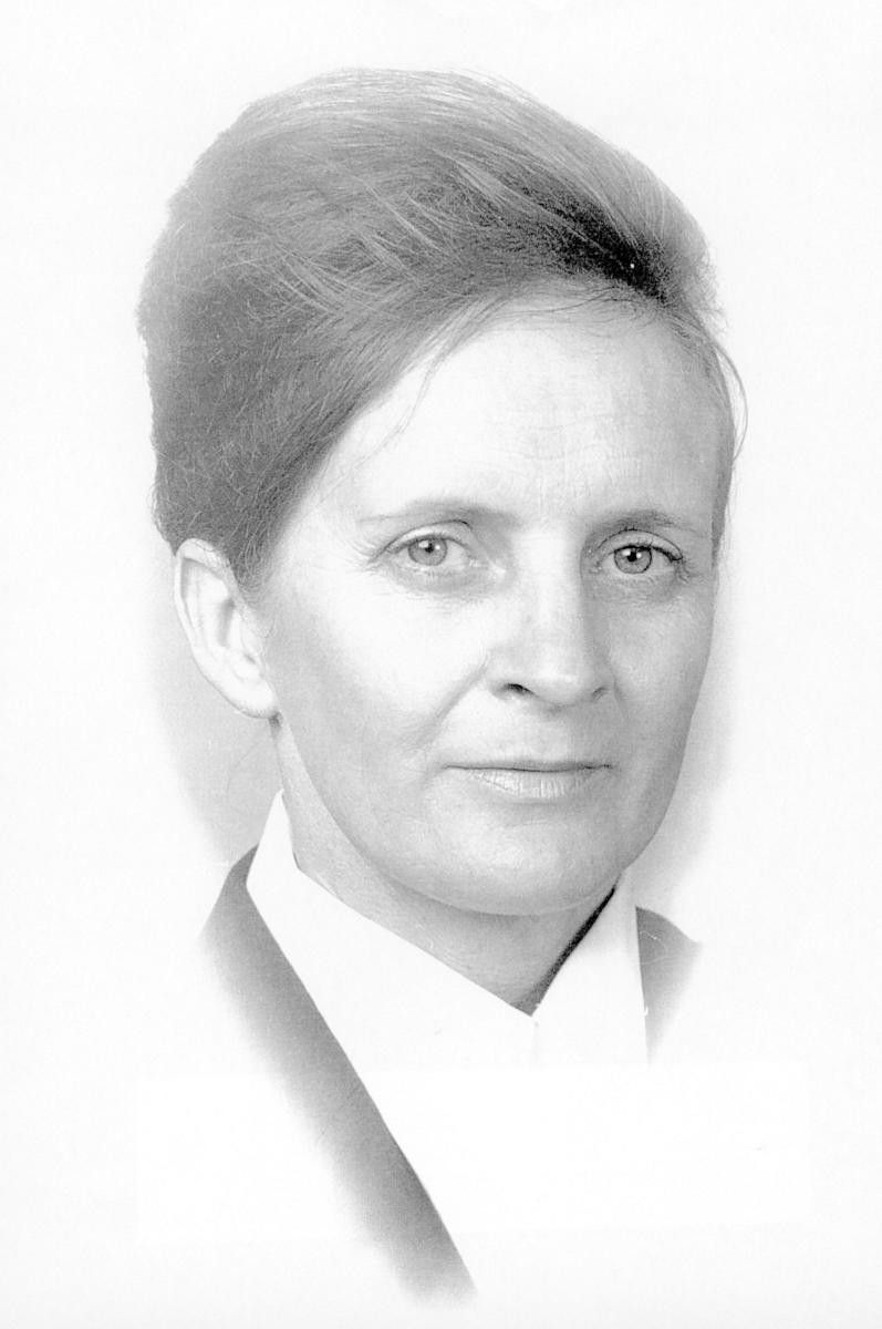 Black-and-white portrait of a person with an updo, wearing a light collared blouse and jacket.