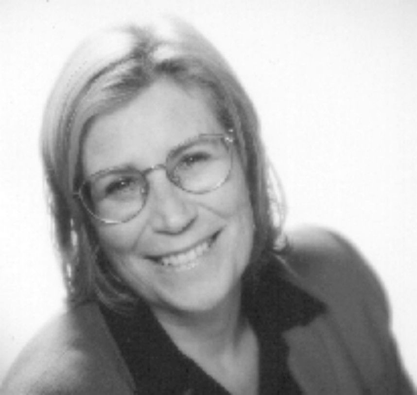 Smiling woman with glasses in a black-and-white portrait