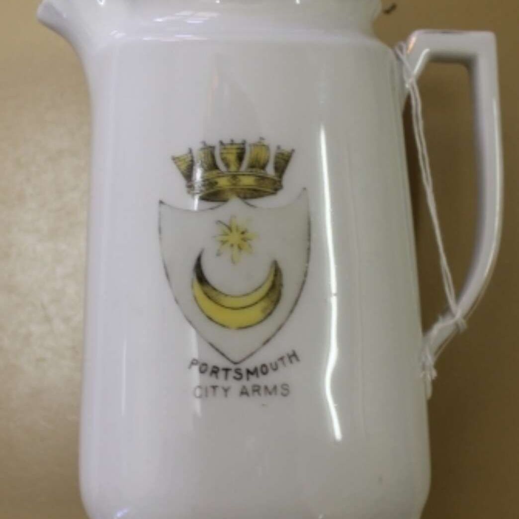 White ceramic mug with Portsmouth City Arms crest and handle on the right