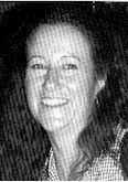Smiling person in a black-and-white portrait, facing the camera.